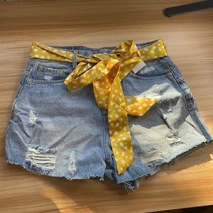 Distressed jean shorts with yellow belt